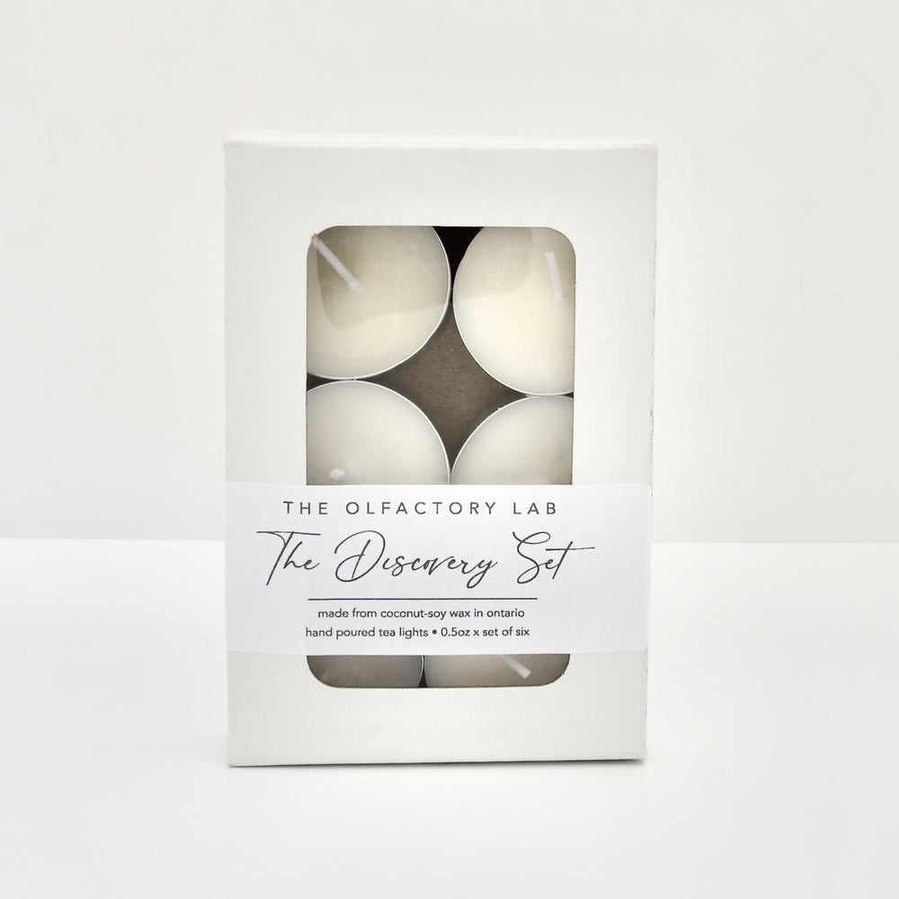 
                  
                    A white box with 6 tea lights inside. The box has a white rectangle label that reads The Discovery Set. The Discovery Set is photographed standing up on a white surface and  white background.
                  
                