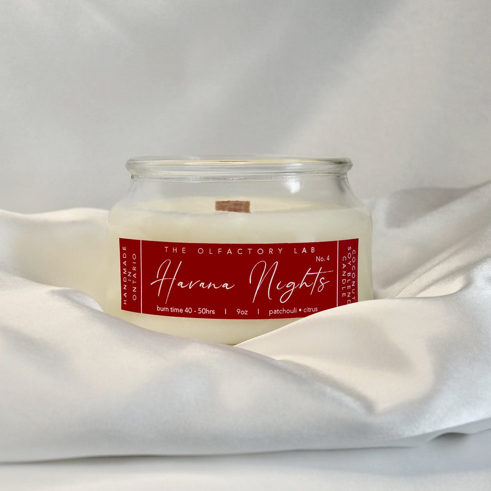 
                  
                    9oz Havana Nights candle. Label is a rectangle in a true red colour with white cursive font. The candle is sitting on white silk with a white background. 
                  
                